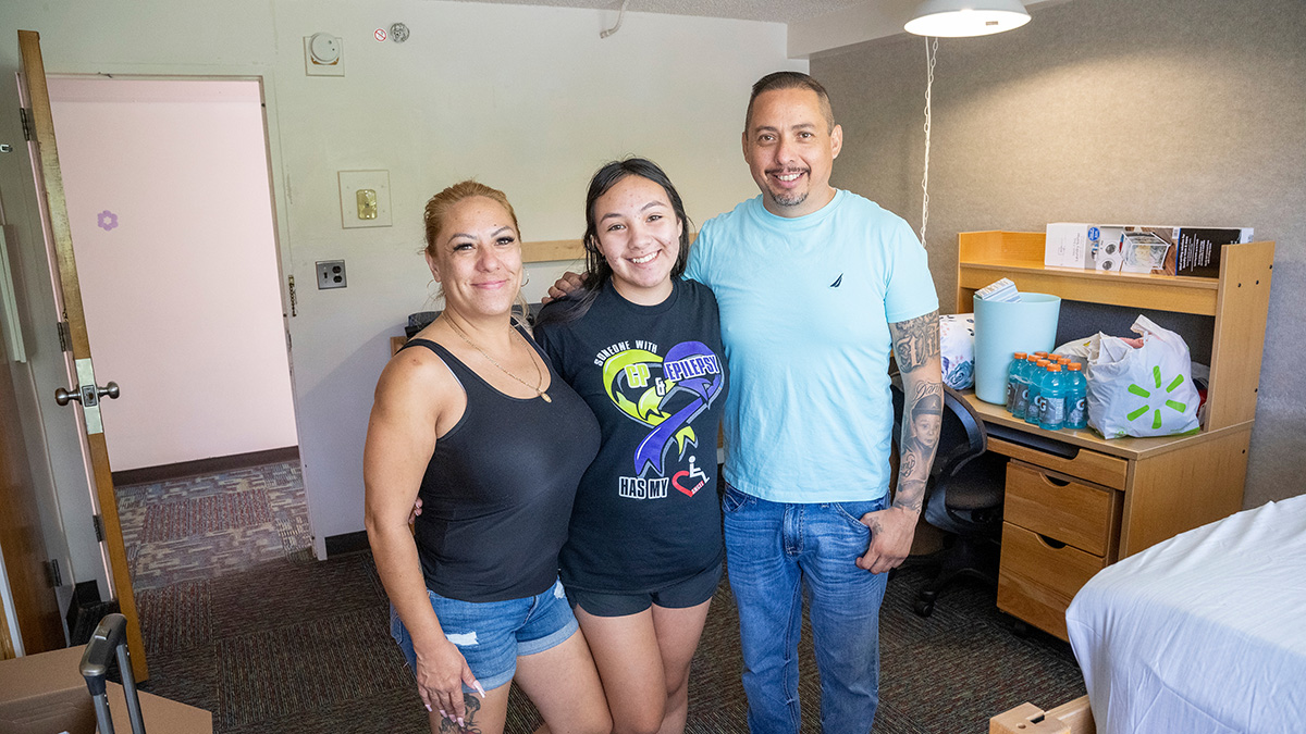 family poses in residence hall room